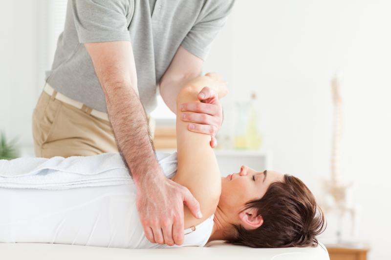A therapist, a patient's shoulder